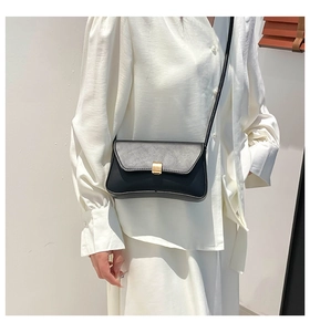 Detail of vintage black leather baguette bag with a premium gold rectangular metal buckle