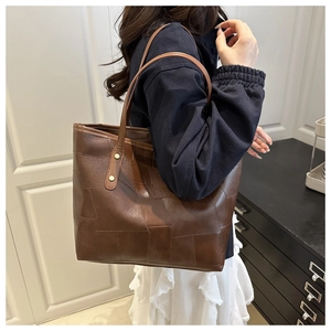 Vue latérale du grand sac cabas marron foncé avec texture et détails de rivets dorés