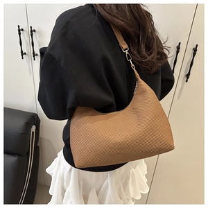 Detailed close-up of brown woven texture hobo bag with sleek leather shoulder strap