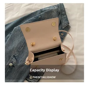 Detail view of pink square mini bag showing inner capacity and magnetic closure
