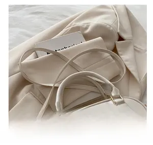 Detail of minimalist beige PU leather shoulder bag with smooth texture and sturdy handle