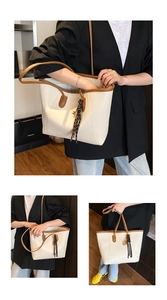 Detail view of beige tote bag with brown handles and elegant striped silk scarf decoration