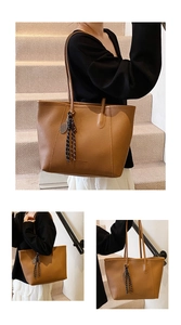 Detailed view of brown lychee grain leather bucket bag with fashion charm and long strap