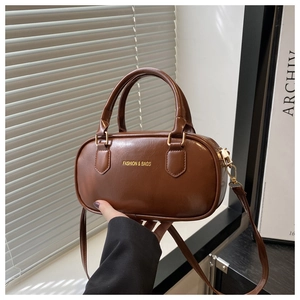 Détail du sac Boston en cuir PU marron foncé avec texte doré et finitions métalliques