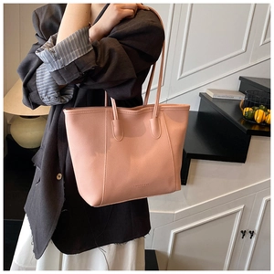 Detail view of pink leather tote bag with elegant thin straps and fashion logo