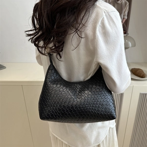 Minimalist black woven hobo shoulder bag for women styled in a chic casual commute look