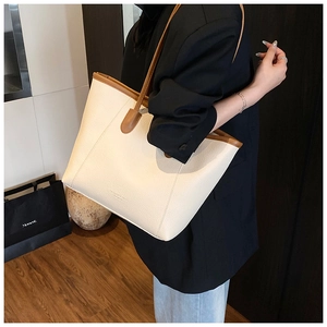 Detail view of cream tote bag with brown straps and FASHION & BAGS lettering
