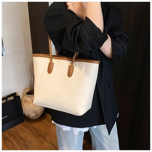 Close-up of cream white lychee leather tote bag with brown handles on shoulder
