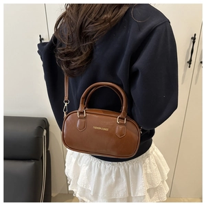 Détail du sac Boston marron vintage avec texte doré et poignées supérieures élégantes