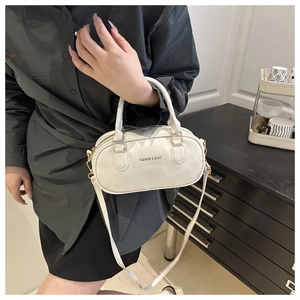 Detail of a white mini Boston bag with glossy PU leather and round handles