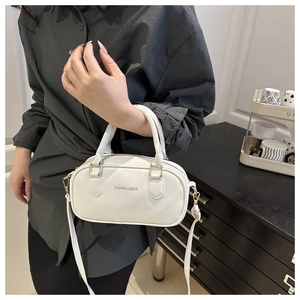 Close-up of a white Boston handbag with smooth leather texture and gold hardware details