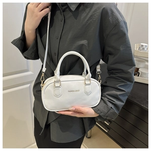 Détail d'un mini sac polochon blanc avec lettrage doré et bandoulière amovible