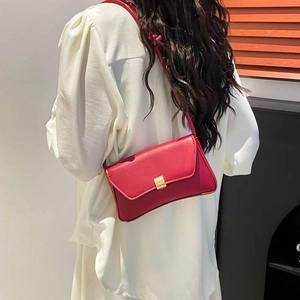 Elegant red PU leather baguette shoulder bag with gold buckle on a model in white blouse