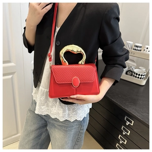 Detail of red leather woven handbag with gold artistic handle and metal buckle on a model
