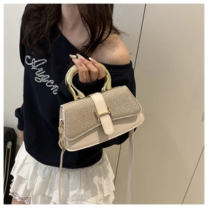 Detail of elegant cream handbag with gold sequin flap and H-shaped metal buckle