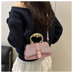 Detail der rosa Glitzertasche mit Goldgriff und Metallschnalle am Model getragen