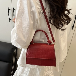 Chic red croc-embossed trapezoid handbag with knotted handle and adjustable shoulder strap