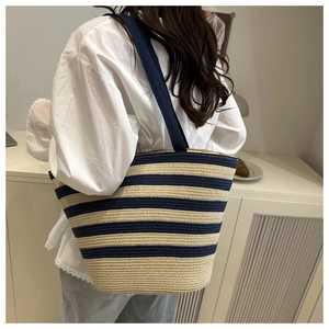 Détail du sac fourre-tout en paille tissé à rayures bleues et blanches et de sa texture