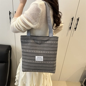 Sac fourre-tout chic en toile à rayures grises avec étiquette de mode en décor intérieur