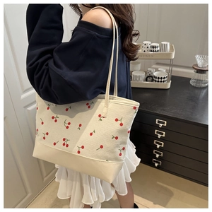 Detail of white corduroy tote bag with cherry embroidery and minimalist shoulder straps