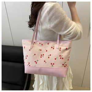 Pink corduroy tote bag detail with cherry embroidery and textured shoulder straps