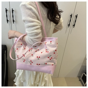 Pink tote bag with cherry print featuring leather bottom and slender shoulder straps