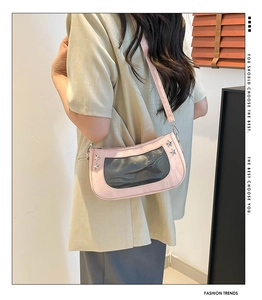 Pink Y2K ita bag with star rivets and clear display window worn by a model as a shoulder bag