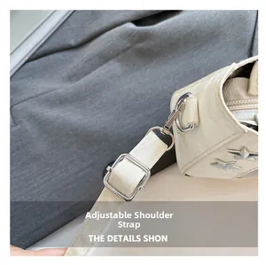 Close-up of adjustable strap and silver star rivets on this white crossbody bag