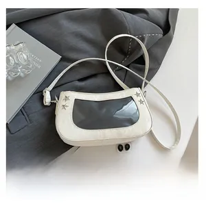 Close-up of a white patent leather bag with a transparent PVC window and star rivets