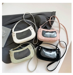 Detail of stylish patent leather bags with transparent window and silver star studs