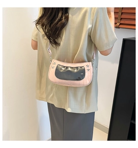 Detail of pink shoulder bag featuring transparent window and silver star rivets