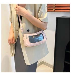 Close-up of pink glossy crossbody bag featuring silver star studs and transparent window