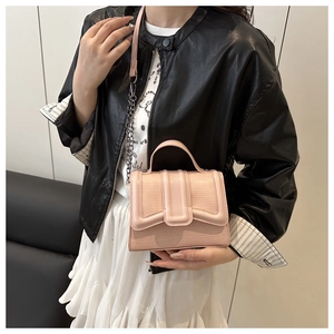 Detail showing the pink crocodile pattern texture on a stylish leather crossbody bag
