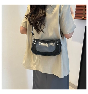 Detail of black ita shoulder bag featuring transparent PVC window and silver star rivets