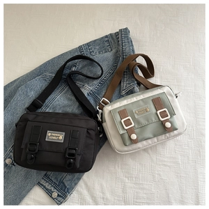 Detailopname van canvas messenger bags in zwart en saliegroen met verstelbare schouderbanden