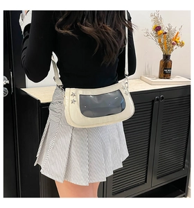 Detail of cream white ita bag with transparent window and silver star studs on shoulder