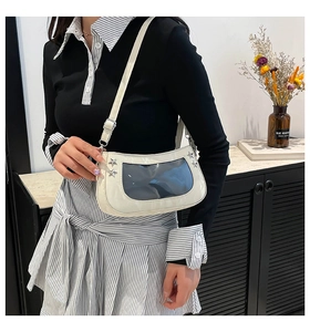 Detail of white PU leather underarm bag featuring clear window and silver star studs