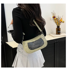 Model wearing a green ita bag with clear window and star studs from a back view
