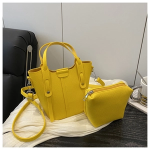 Detailed macro view of yellow bucket bag with lychee texture and matching small pouch