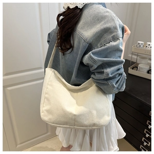 Dettaglio della texture della borsa hobo in velluto a coste bianco con tracolla