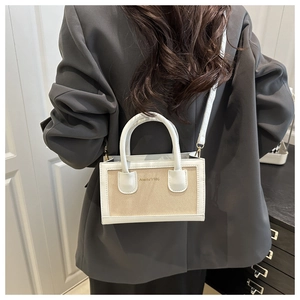 Detail of Amity 1986 canvas handbag showing beige woven texture and white leather trims