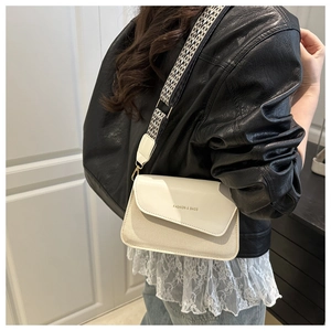 Detail of crossbody bag with wide geometric strap and Fashion & Bags text on cover