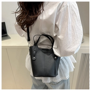 Close-up of black lychee grain bucket bag with silver rivet details and slim strap