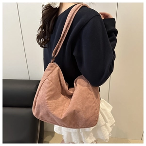 Dettaglio della texture della borsa tote in velluto rosa e tasca laterale della borsa