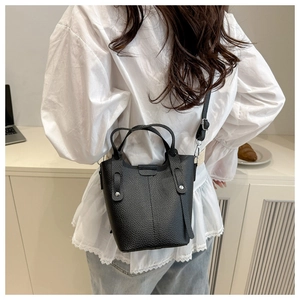 Detailed back view of a black pebbled leather bucket bag with silver buckle strap