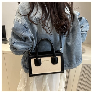 Modern black and cream canvas crossbody bag shown on model with casual summer denim outfit