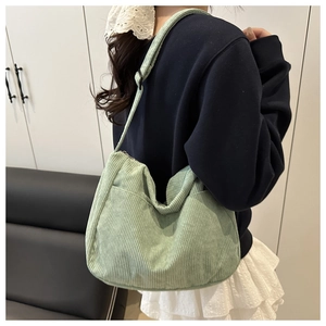 Dettaglio della borsa tote in velluto a coste verde menta con due tasche anteriori