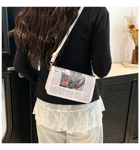 Détail du petit sac bandoulière carré à imprimé journal vintage porté par un mannequin