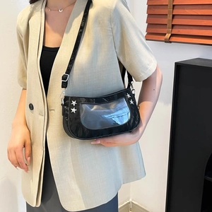 Black underarm bag with silver star studs and transparent window on light suit