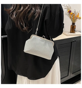 Détail du sac argenté à paillettes avec chaîne en perles sur la tenue du modèle